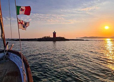 Vintage boat sailing excursion in the Gulf of Alghero at sunset with tasting